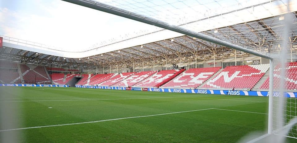 Campo de fútbol con gradas vacías y césped verde
