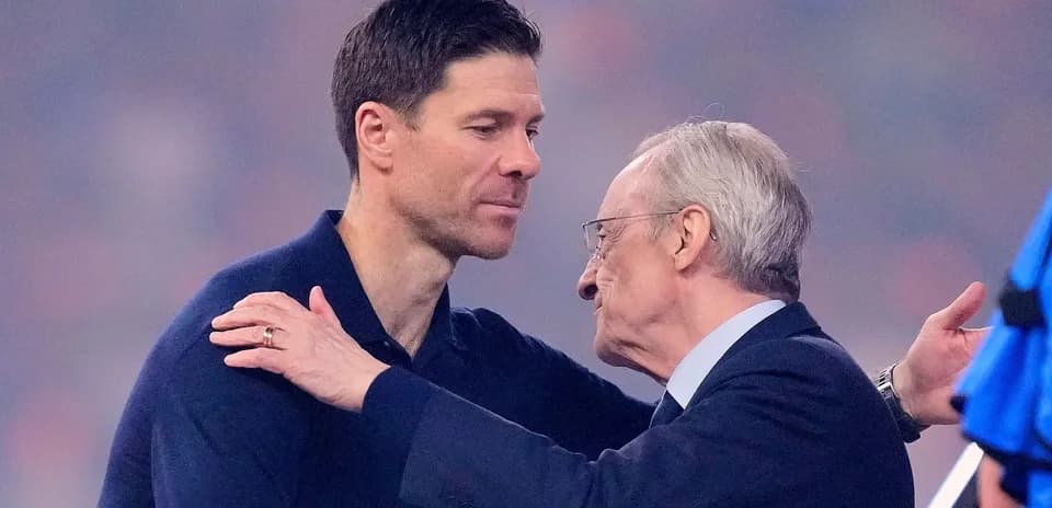 Entrenador y directivo saludándose en el estadio