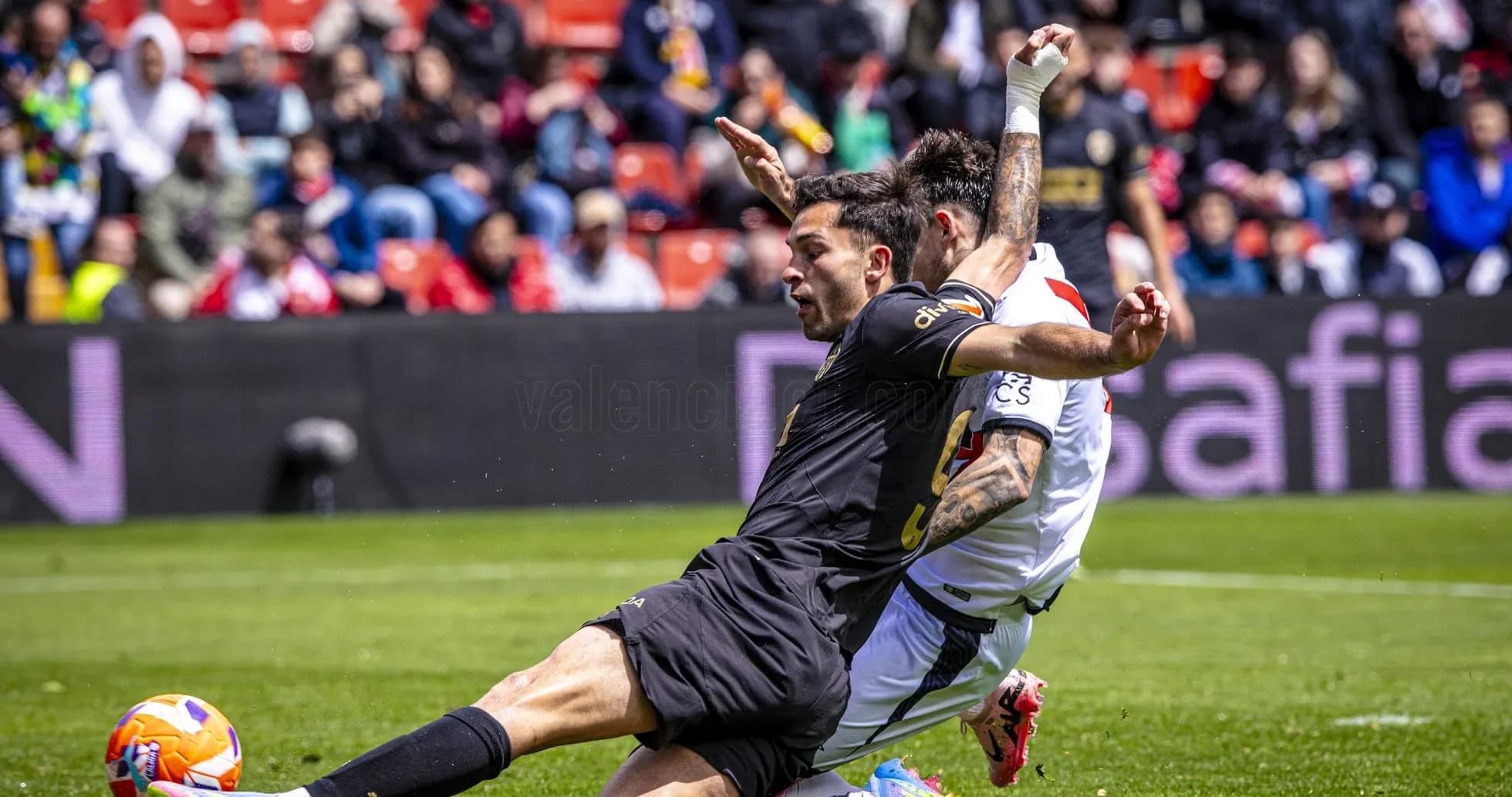 Jugador de Valencia derribando a un rival