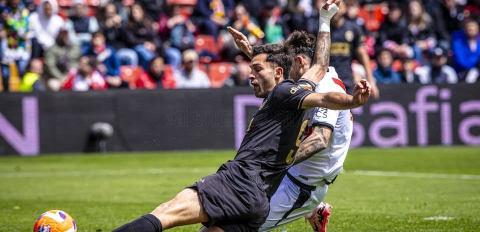 Jugador de Valencia derribando a un rival
