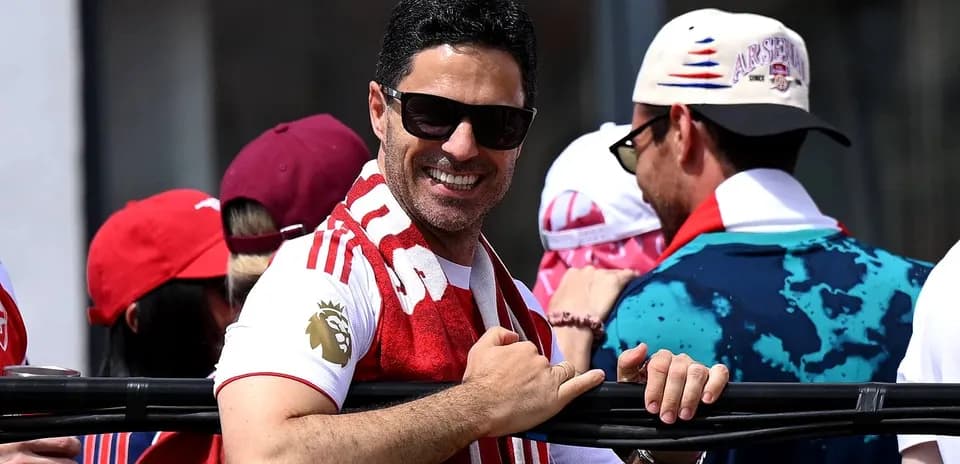 Hombre sonriente con bufanda en evento deportivo