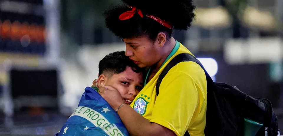 Madre abrazando a su hijo envuelto en bandera brasileña
