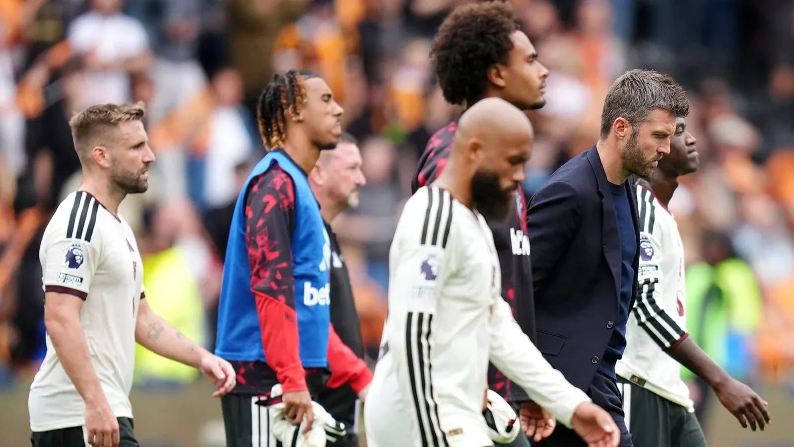 Jugadores y entrenador caminando tras el partido