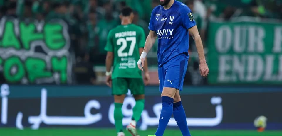 Jugador con camiseta azul caminando en el campo