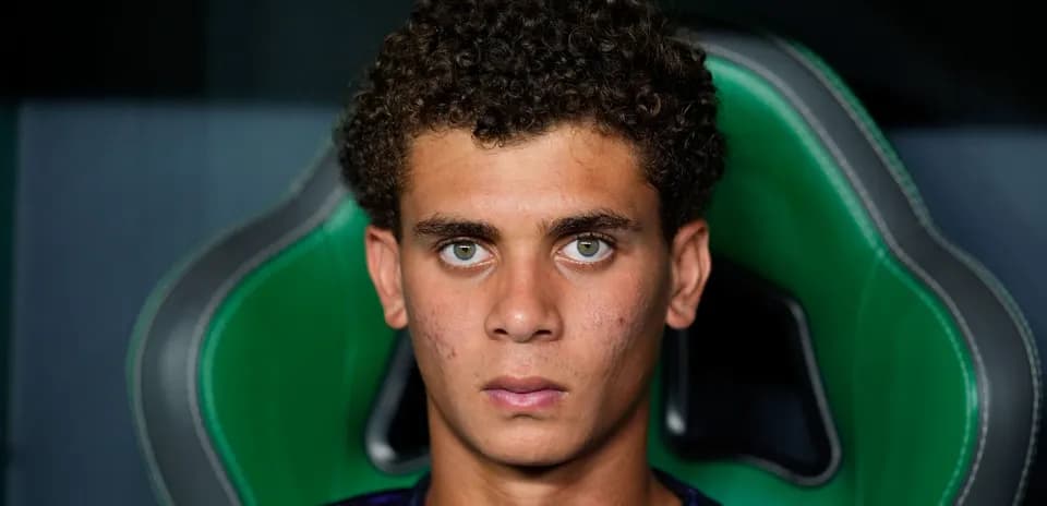 Jugador sentado en silla de equipo, mirada seria