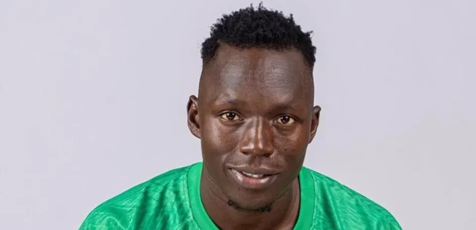 Jugador de fútbol en camiseta verde posando para foto