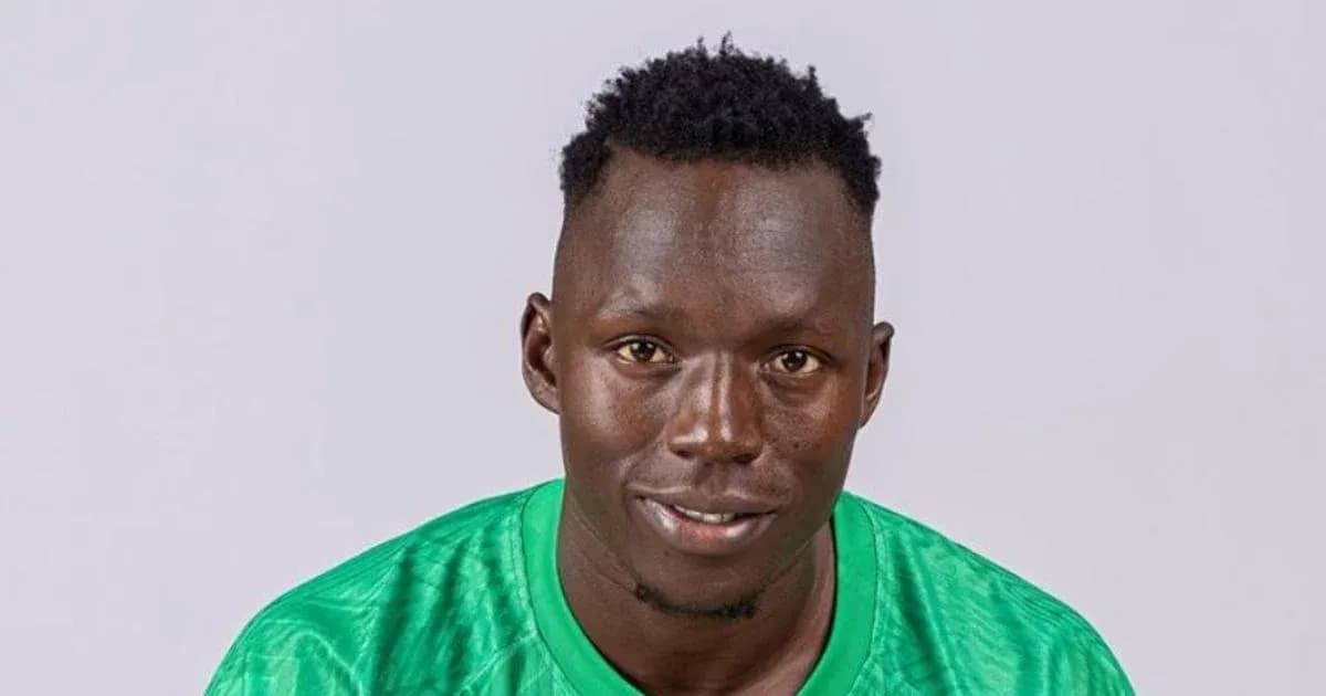 Jugador de fútbol en camiseta verde posando para foto