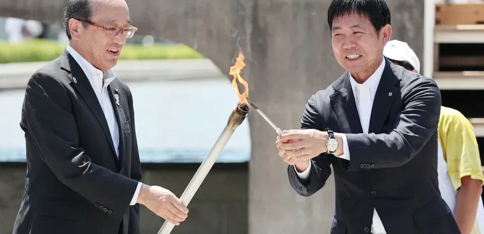 Dos personas encendiendo una antorcha ceremonial