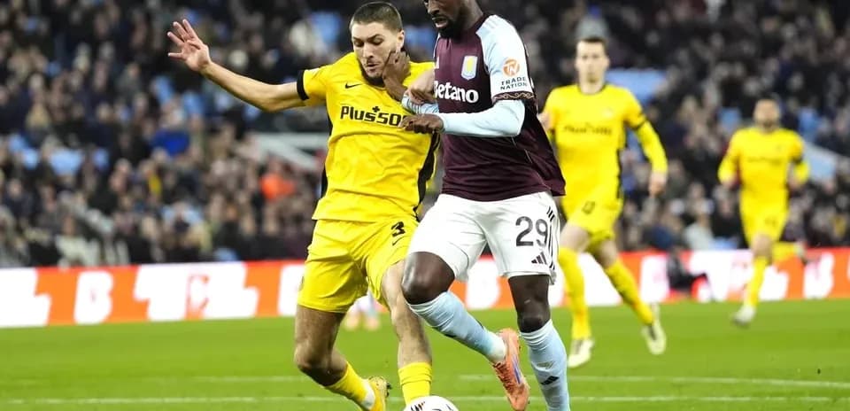Jugador de Aston Villa driblando ante defensa rival