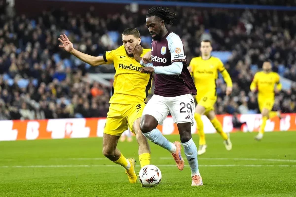 Jugador de Aston Villa driblando ante defensa rival