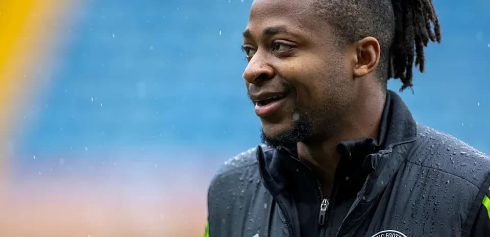 Jugador de fútbol con chaqueta de entrenamiento en lluvia