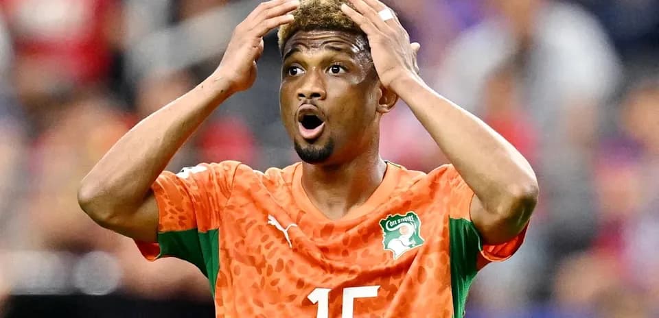 Jugador de Costa de Marfil con camiseta naranja sorprendiendo