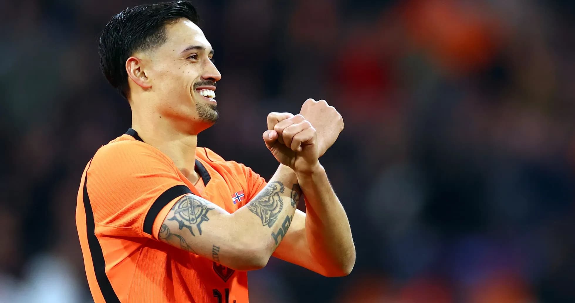 Jugador celebrando con camiseta naranja en el campo