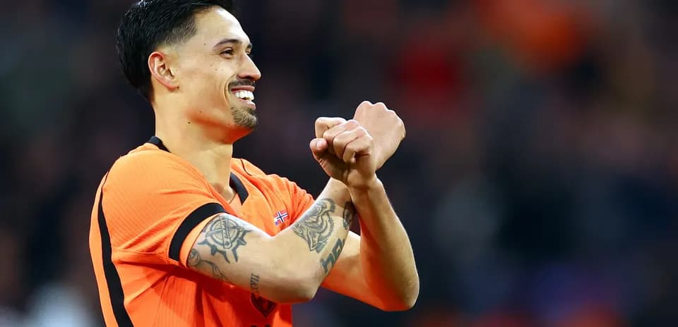 Jugador celebrando con camiseta naranja en el campo