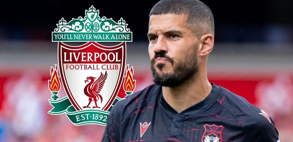 Jugador de fútbol frente al escudo del Liverpool