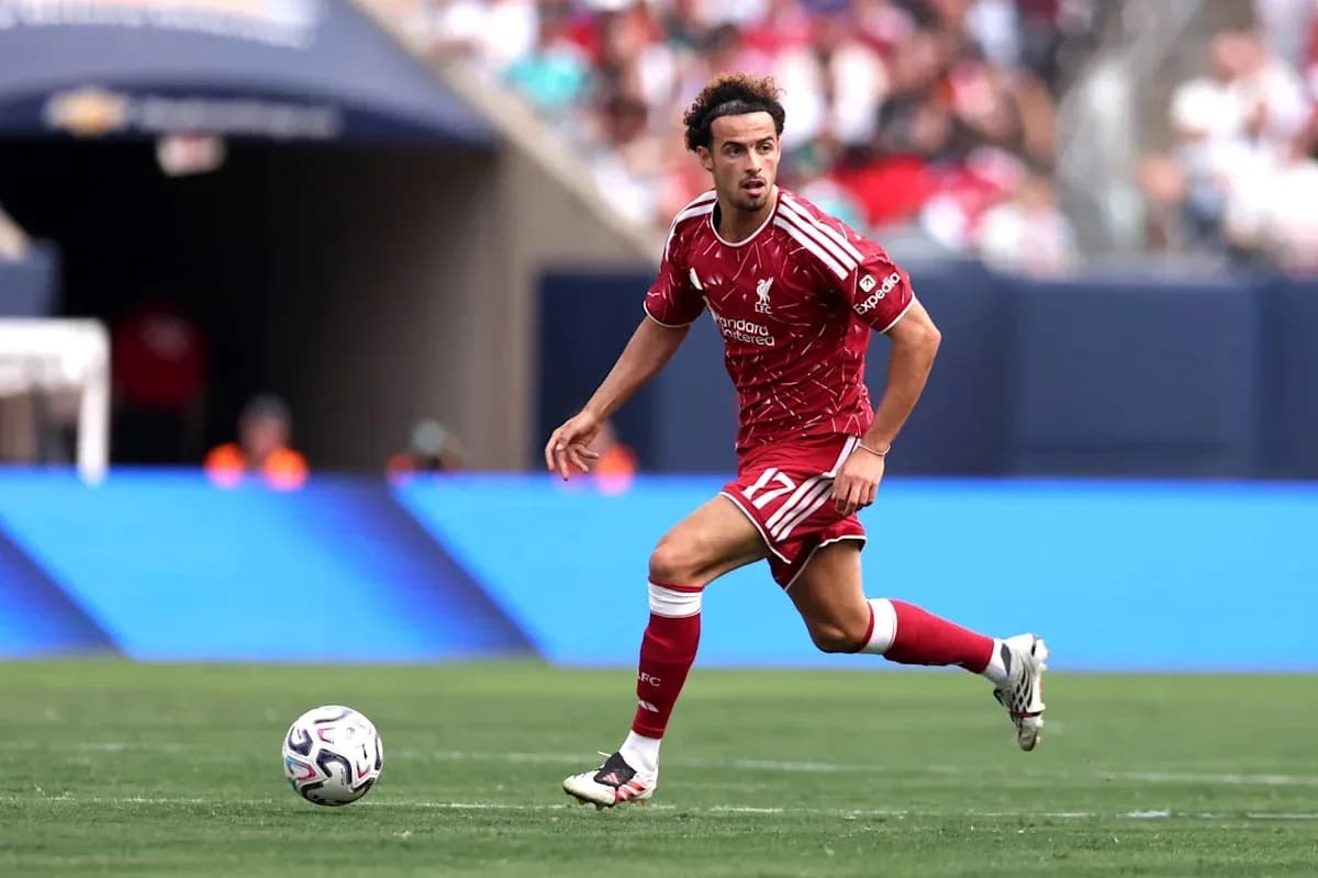 Jugador de Liverpool corriendo con el balón en el campo