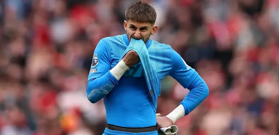 Portero con camiseta azul sosteniendo una toalla