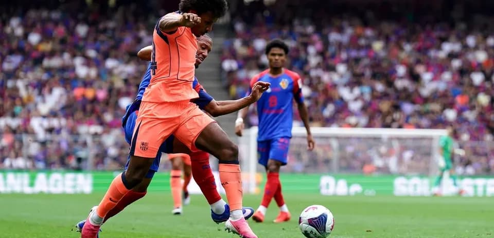 Jugador del Barça desafiando a oponente en el campo