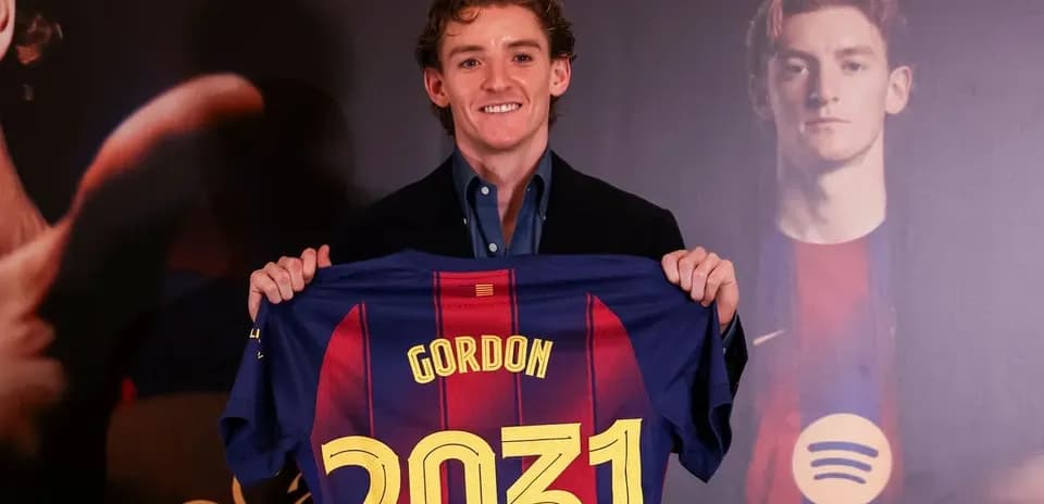 Jugador sosteniendo camiseta del FC Barcelona con su nombre