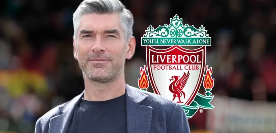 Hombre posando frente al logo de Liverpool FC