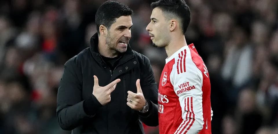 Entrenador hablando con jugador en partido de fútbol