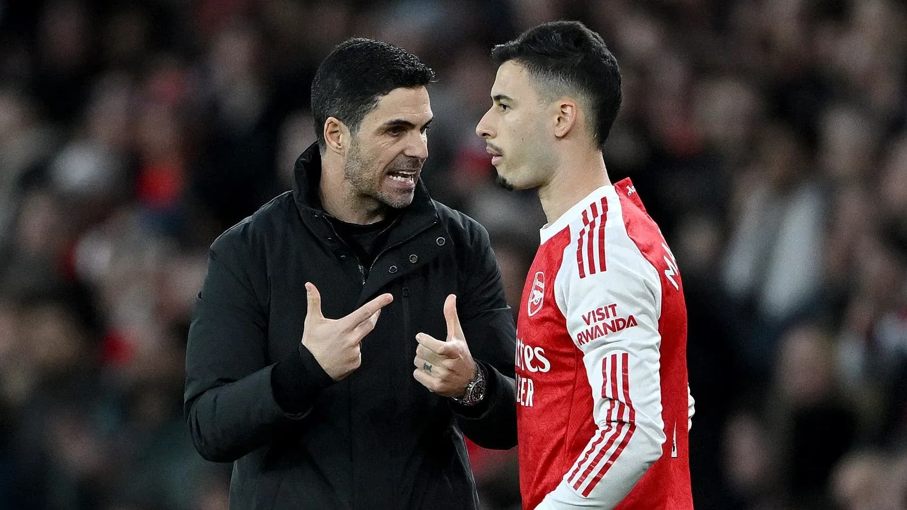 Entrenador hablando con jugador en partido de fútbol