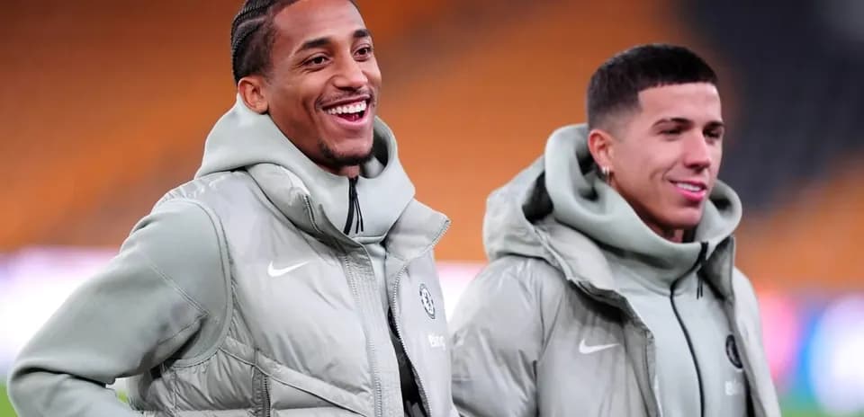 Dos jugadores sonriendo durante calentamiento en el campo
