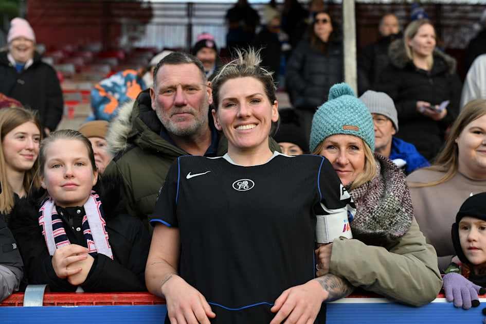 Jugadora sonriente con aficionados en el estadio