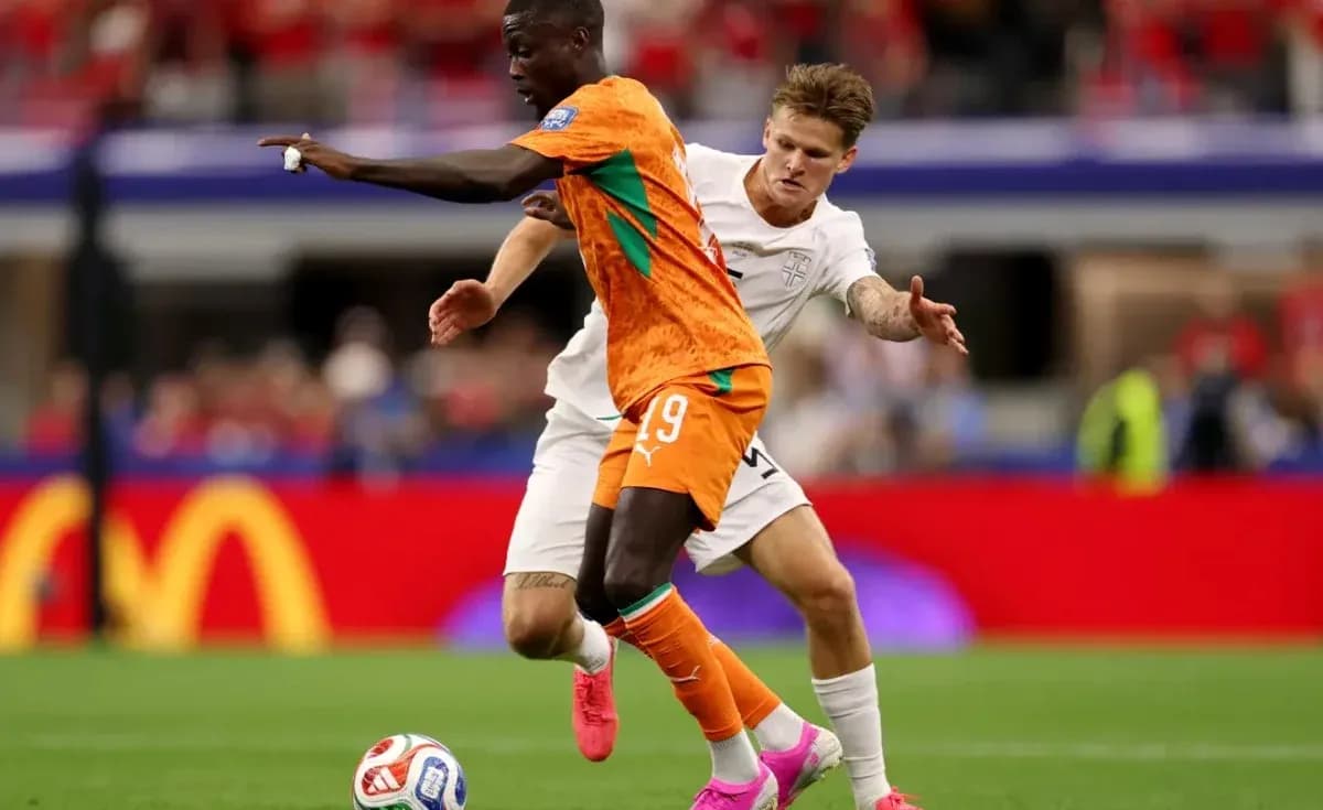 Jugador con camiseta naranja driblando a oponente en campo