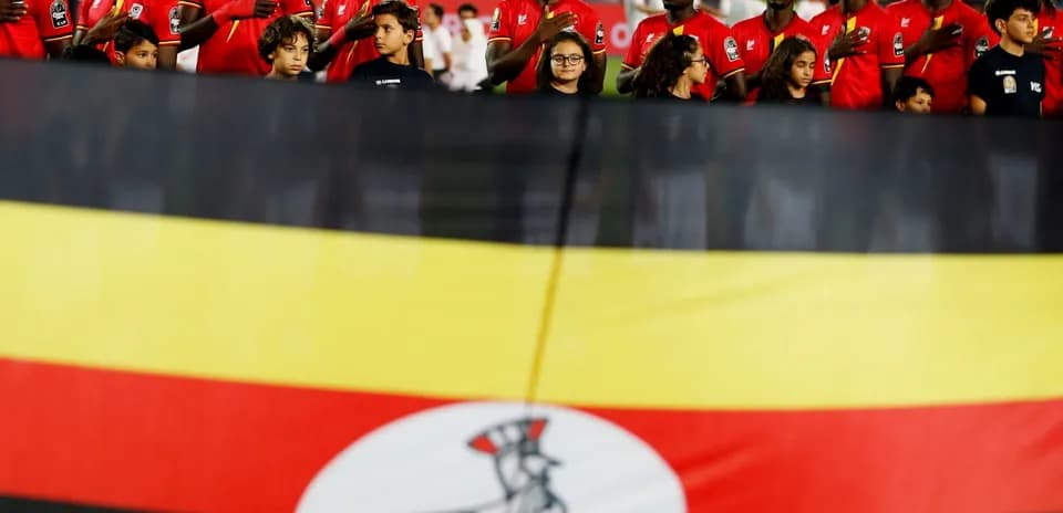 Jugadores de Uganda cantando himno frente a bandera