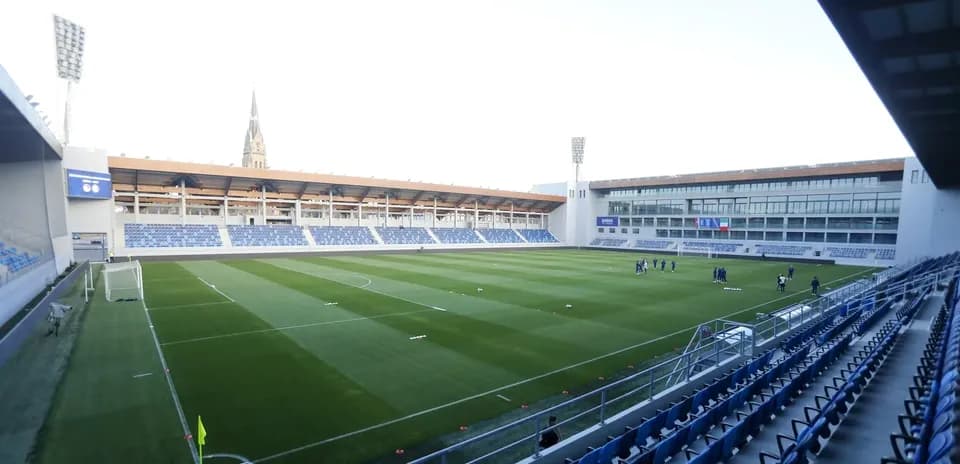 Estadio vacío con jugadores en el campo de entrenamiento