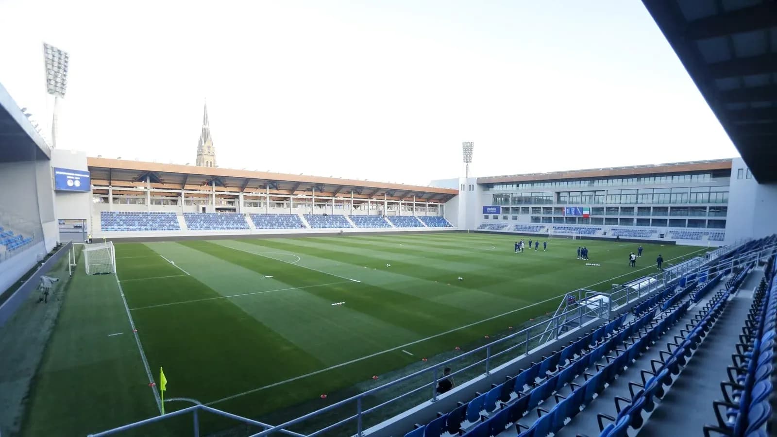 Estadio vacío con jugadores en el campo de entrenamiento
