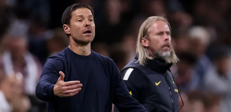 Entrenador gesticulando durante un partido de fútbol