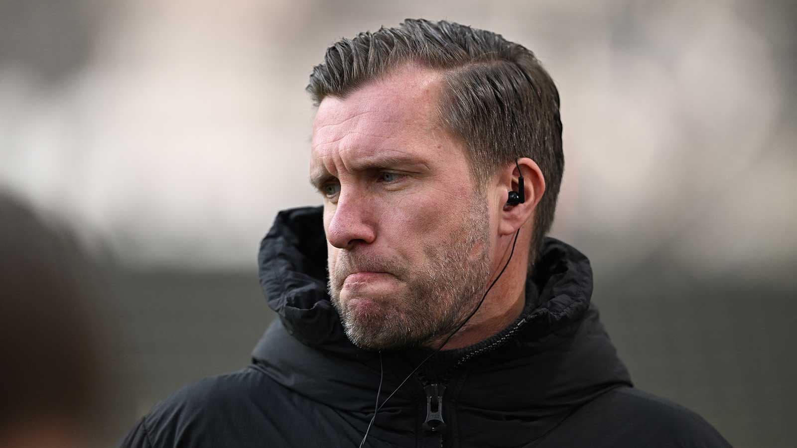 Entrenador con auriculares en campo de entrenamiento