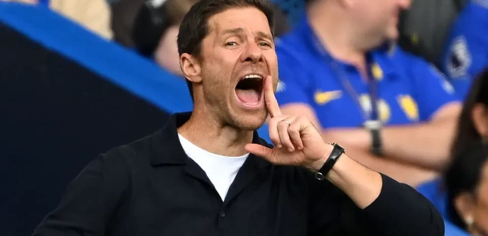 Entrenador dando instrucciones desde la banda del campo