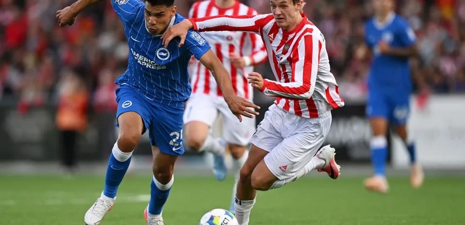 Jugador de Brighton driblando mientras es presionado