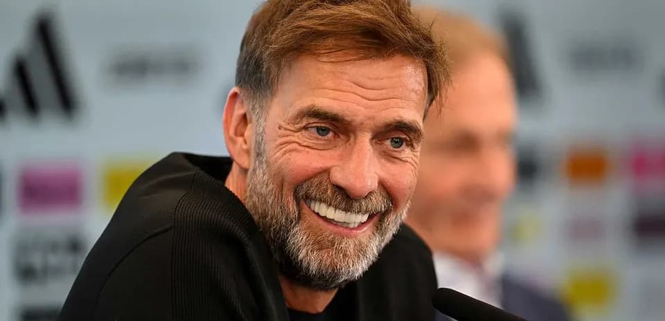 Entrenador sonriendo en conferencia de prensa