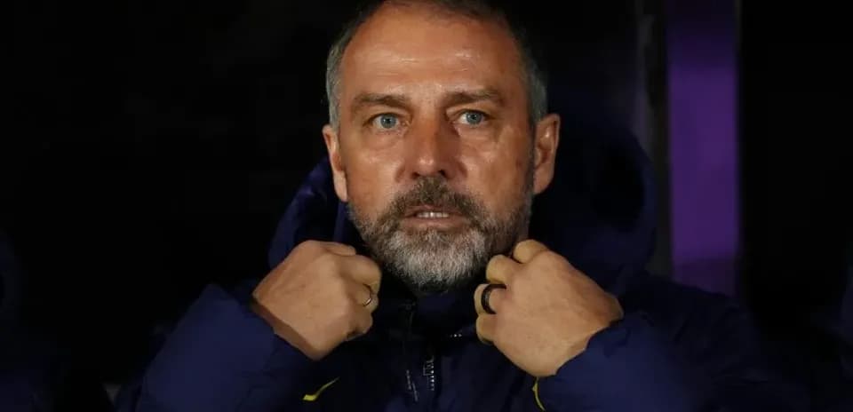 Entrenador ajustando su chaqueta en el banquillo