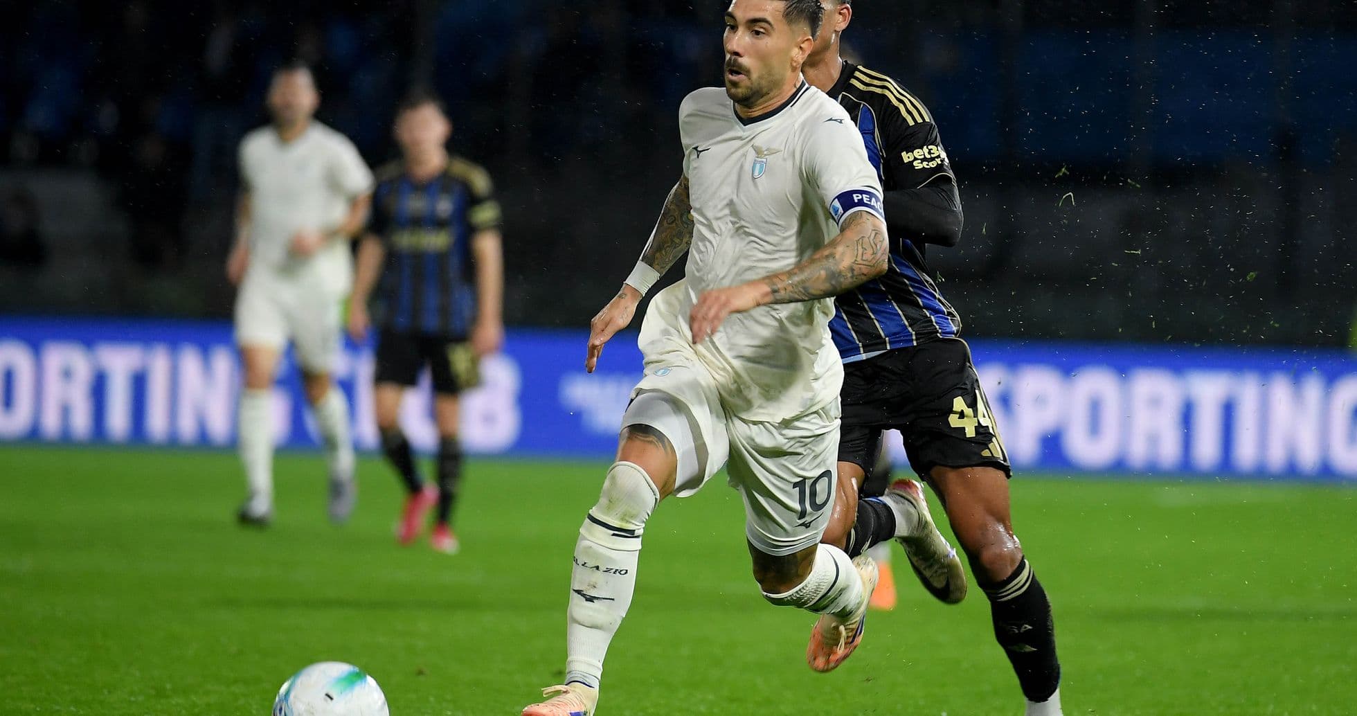 Jugador de Lazio esquivando a defensor de Pisa