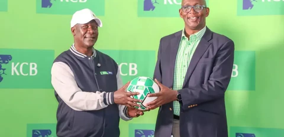 Dos personas sosteniendo un balón de fútbol en evento