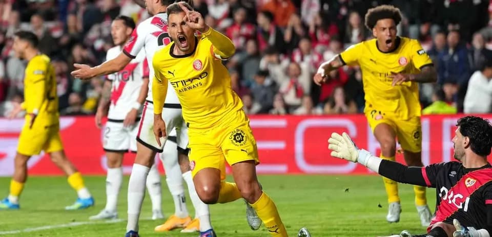 Jugador celebra un gol mientras el portero observa