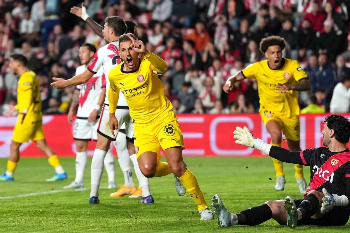 Jugador celebra un gol mientras el portero observa