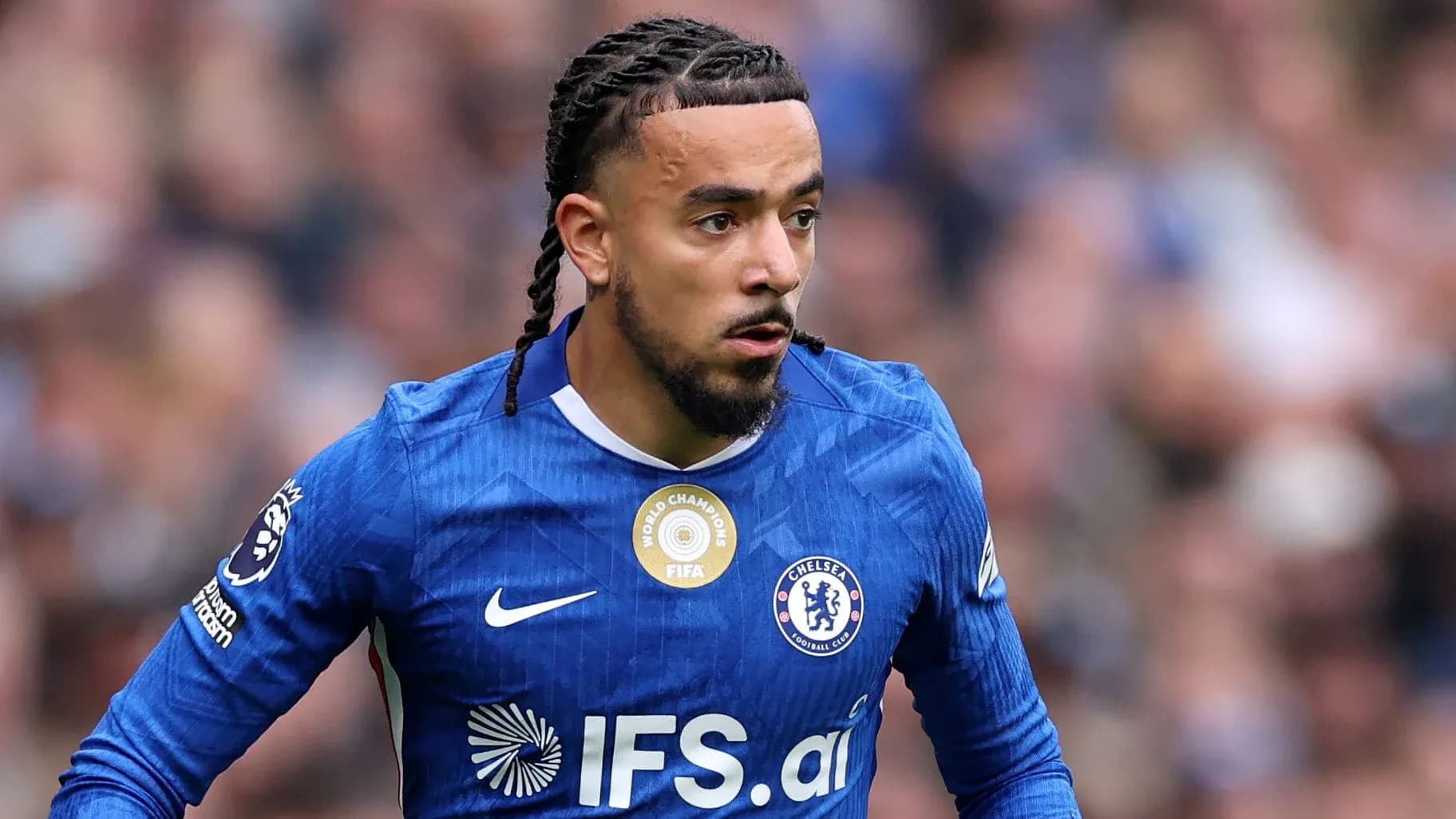 Jugador de Chelsea corriendo con balón en el campo