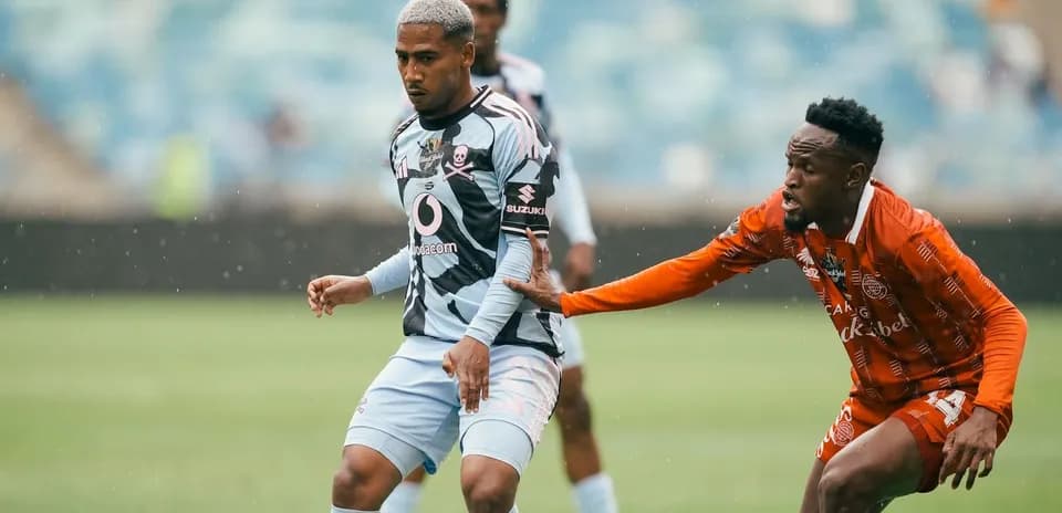 Jugador esquivando a oponente en un partido de fútbol