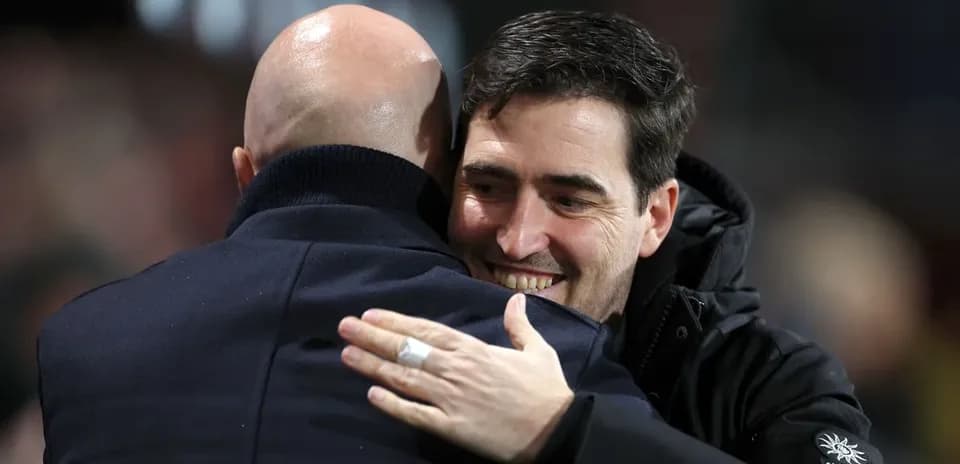 Dos entrenadores abrazándose en el campo