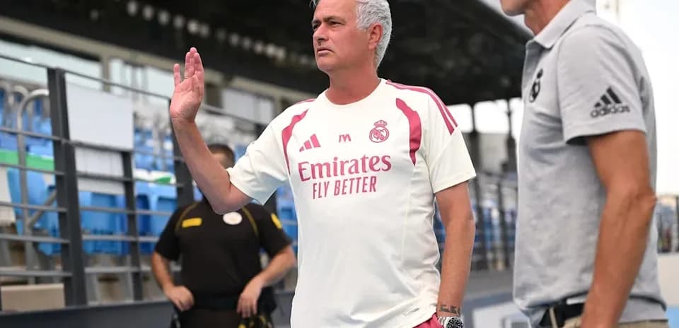 Entrenador saludando durante un evento en el estadio