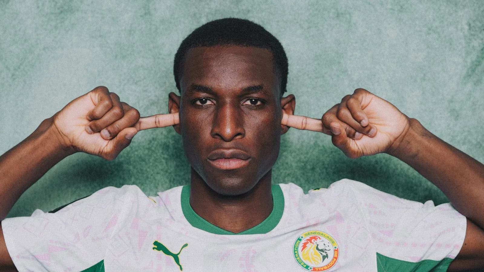 Jugador de Senegal tapándose los oídos con las manos