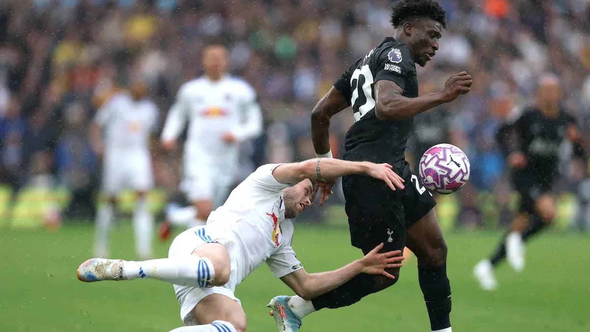 Jugador de Tottenham driblando mientras es tackleado