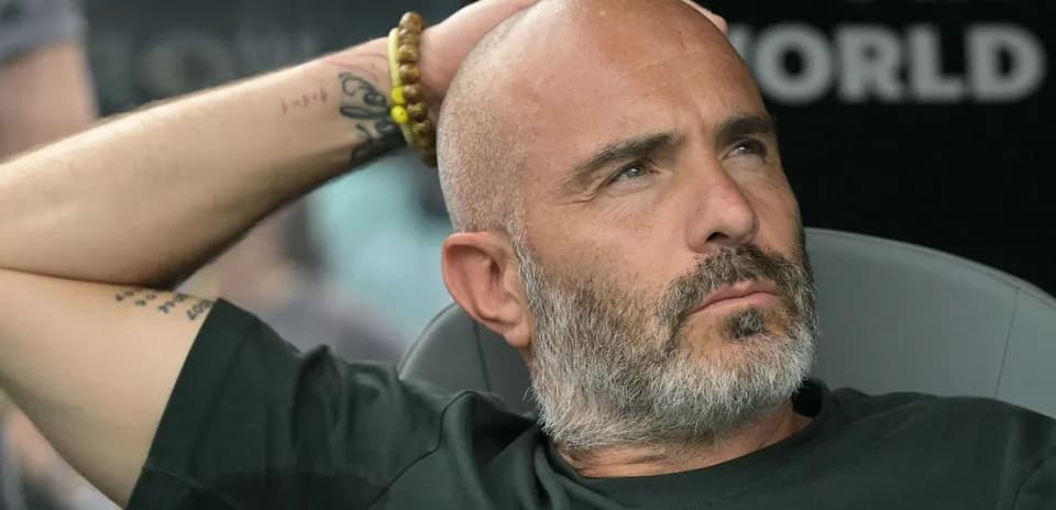 Entrenador sentado con mano en la cabeza