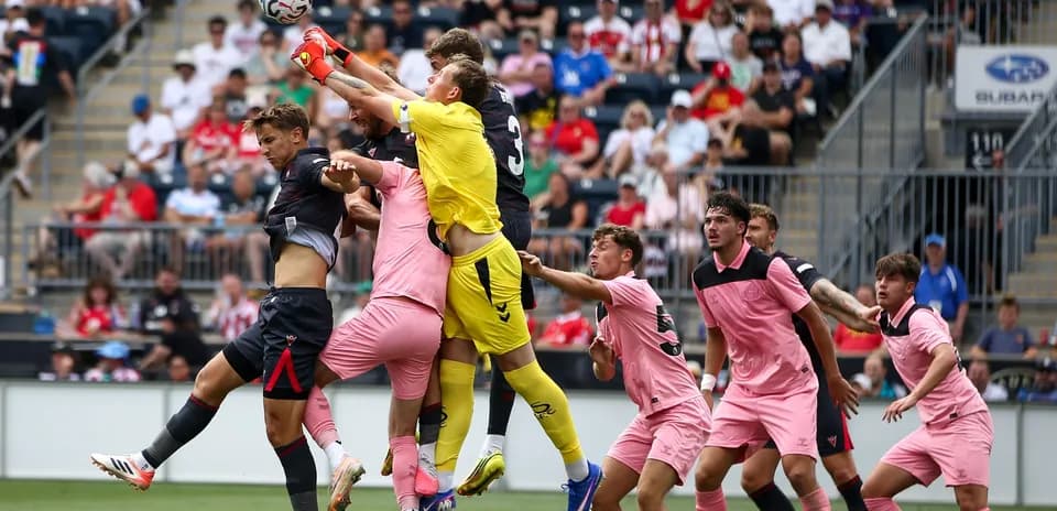 Portero saltando para atrapar el balón en el área